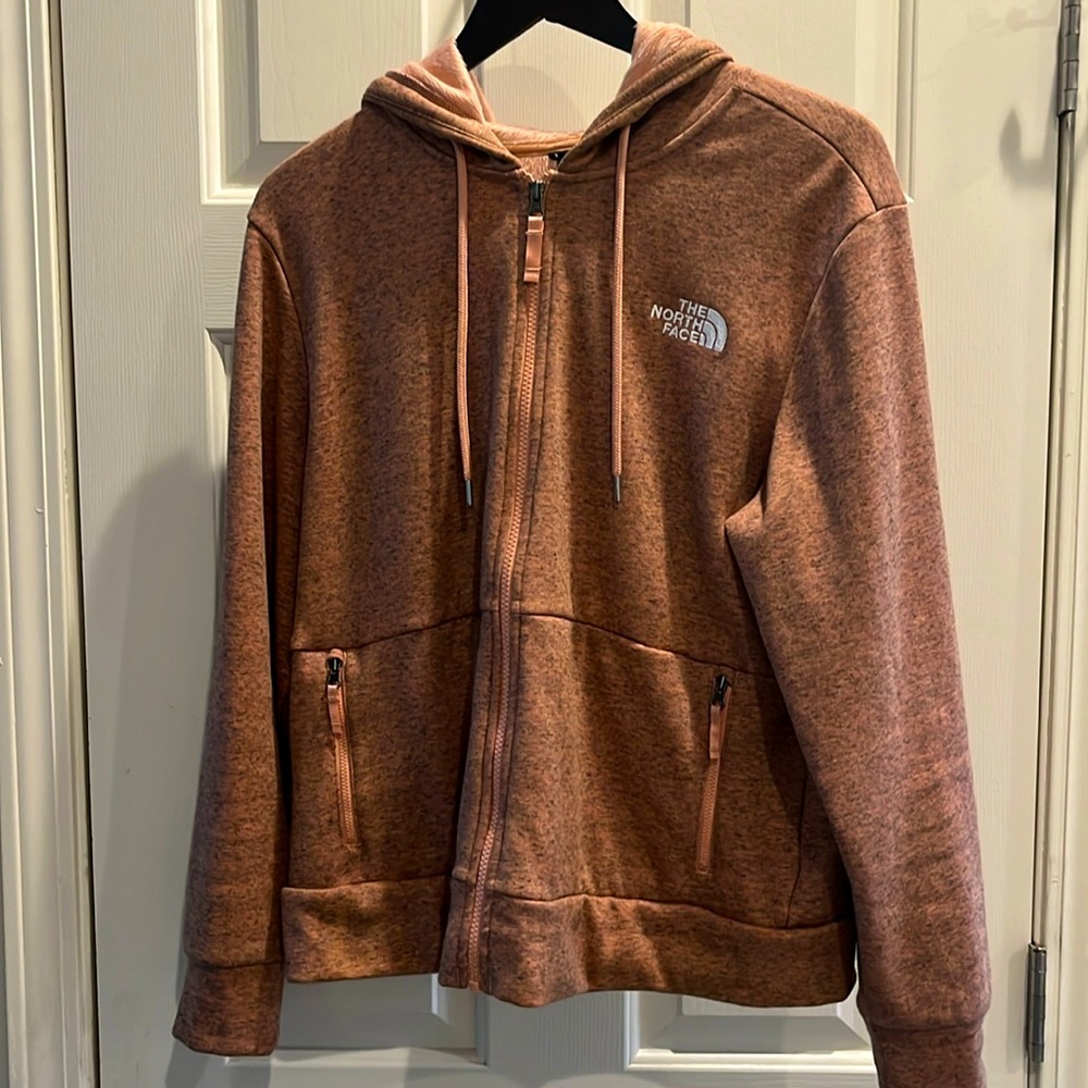 The North Face Pink/salmon color zip-up hoodie with ultra soft fleece lining.